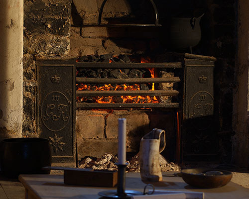 Fireplace within the French prisoners vault in the recreated prisons of war. This original grate bears the cypher of George III (1760-1820)